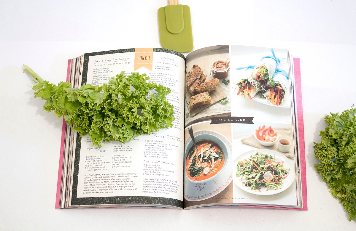 imagine cu o carte de bucate deschisa, cu fotografii de preparate si retete, imagine reprezentativa pentru cărți de bucate semnate de bucătari români