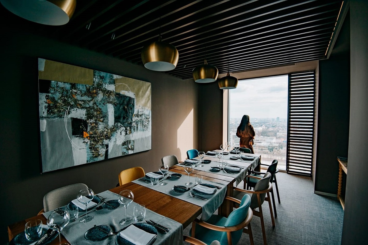 imagine dintr-un separau de la Fork Ana Tower, cu o masa lunga si o femeie in fata unui geam mare, restaurante noi București 2021