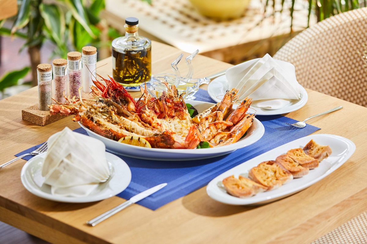 platou cu fructe de mare creveti, pe stergar albastru, pe masa de lemn, la restaurant dancing lobster terasă bucurești