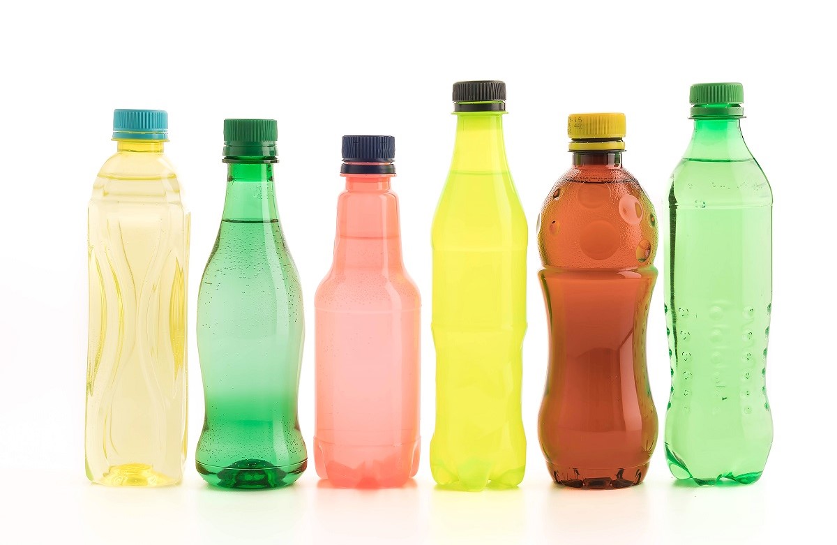 6 sticle cu suc, de culori si inaltime diferite, fotografiate pe fundal alb, ca sugestie pentru alimente sănătoase care conin zahăr