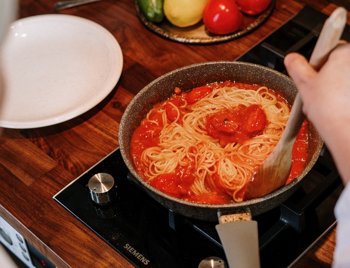 tigaie cu spaghete gatite in sos rosu, pe aragaz