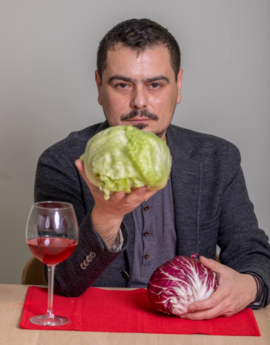 Cosmin Dragomir cu 2 verze in fiecare mana, si un pahar de vin in fata, imagine interviu Restograf