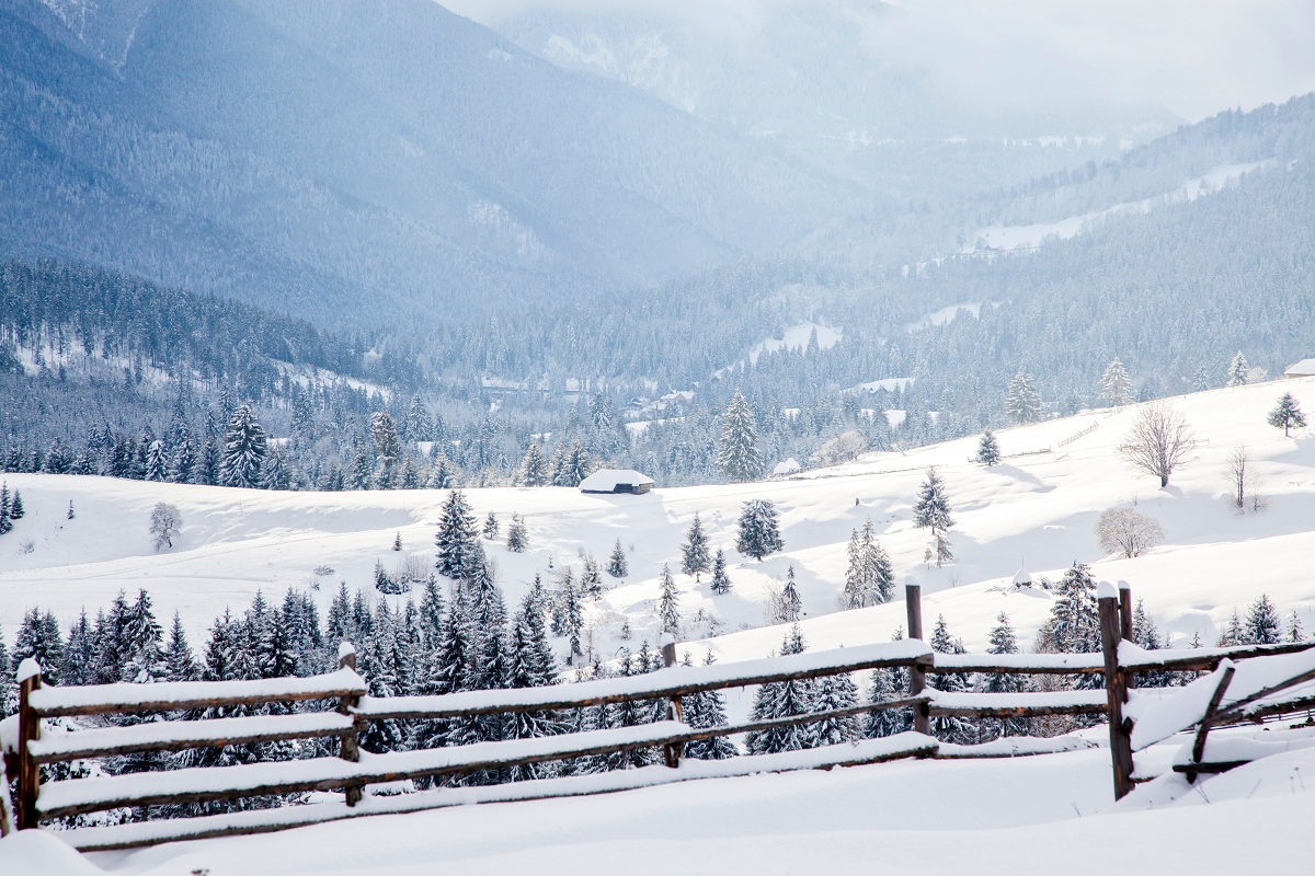 Iarna la munte - satuc mic din Munții Carpați, acoperit de zăpadă - imagine concept pentru Revelionul la munte