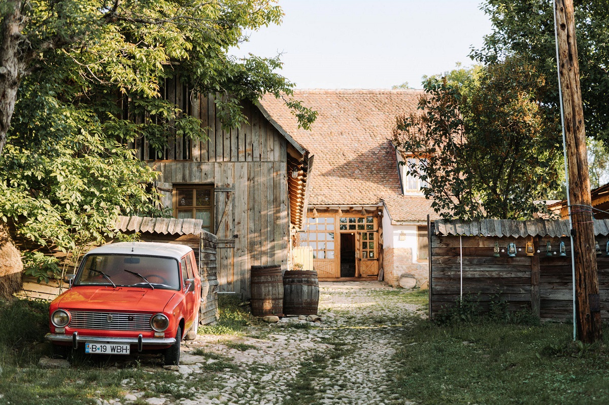casa batraneasca, specifica Transilvaniei, ci curtea sa in care se afla un Trabant roșu, la Viscri 32, una din destinații de tip retreat din România