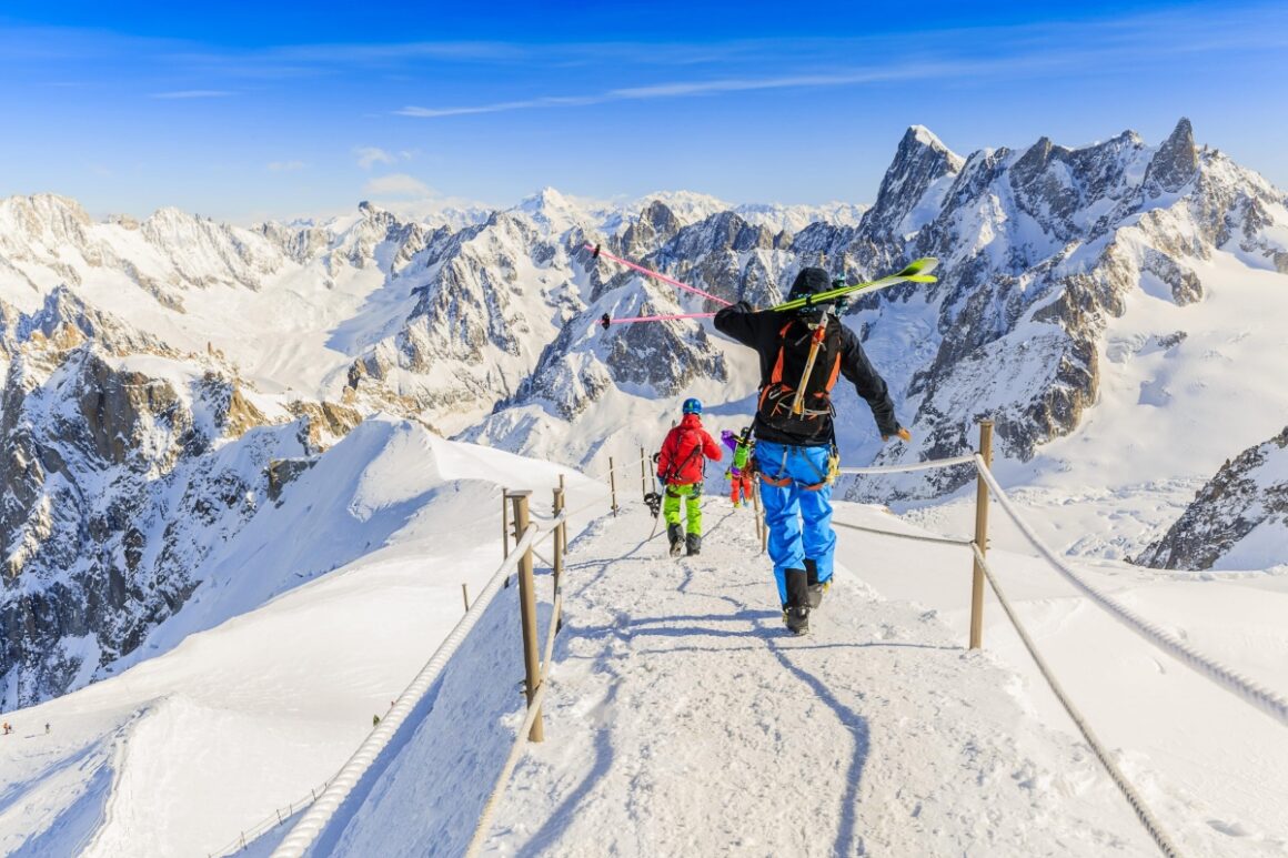 Doi barbati echipati cu costume de schi pe crestele munților din Chamonix - una din destinații de ski din Europa