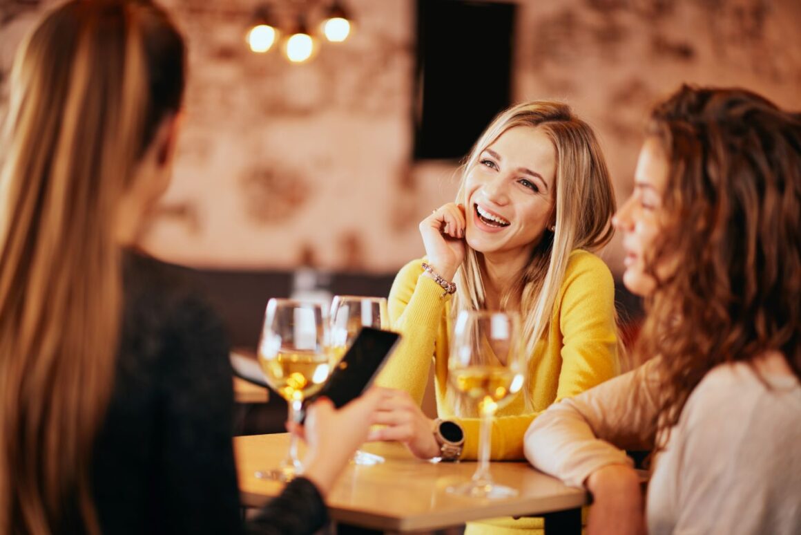 3 prietene la restaurant, la un pahar de vin - imagine reprezentativă pentru unde să ieși cu prietenele de 1 martie