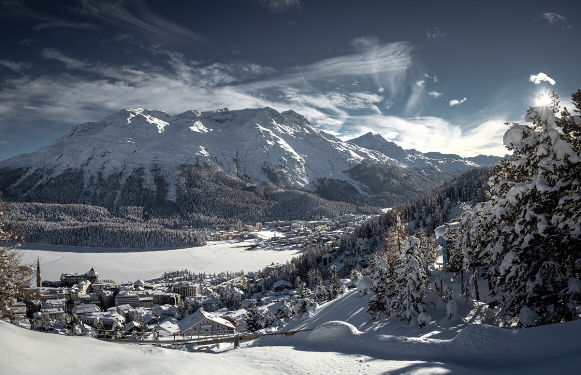 Vedere panoramica asupra statiunii St. Moritz din Elvetia, cu muntii si valea acoperite de zăpadă