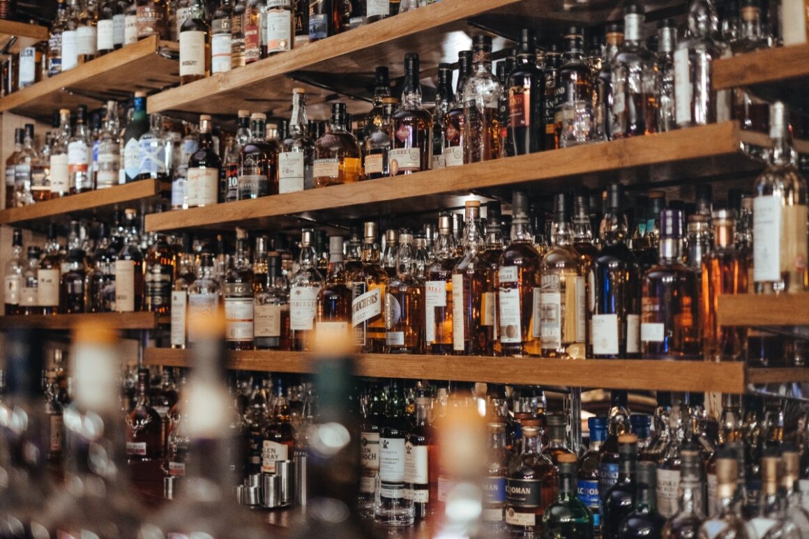 rafturi de lemn dintr-un bar cu diferite tipuri de whiskey